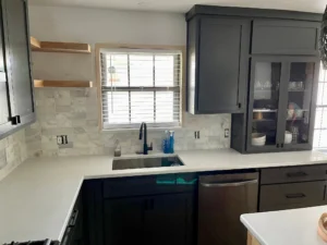 Dark gray shaker cabinets, white countertops, and a white marble subway tile backsplash around a sink