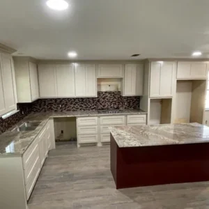 Kitchen remodel with off-white cabinets, granite countertops, a dark red island, and mosaic tile backsplash