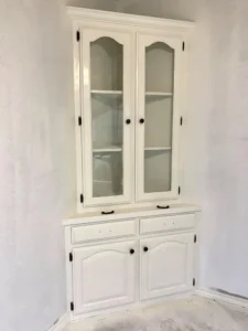 White corner hutch cabinet with glass upper doors and closed lower storage, ready for hardware